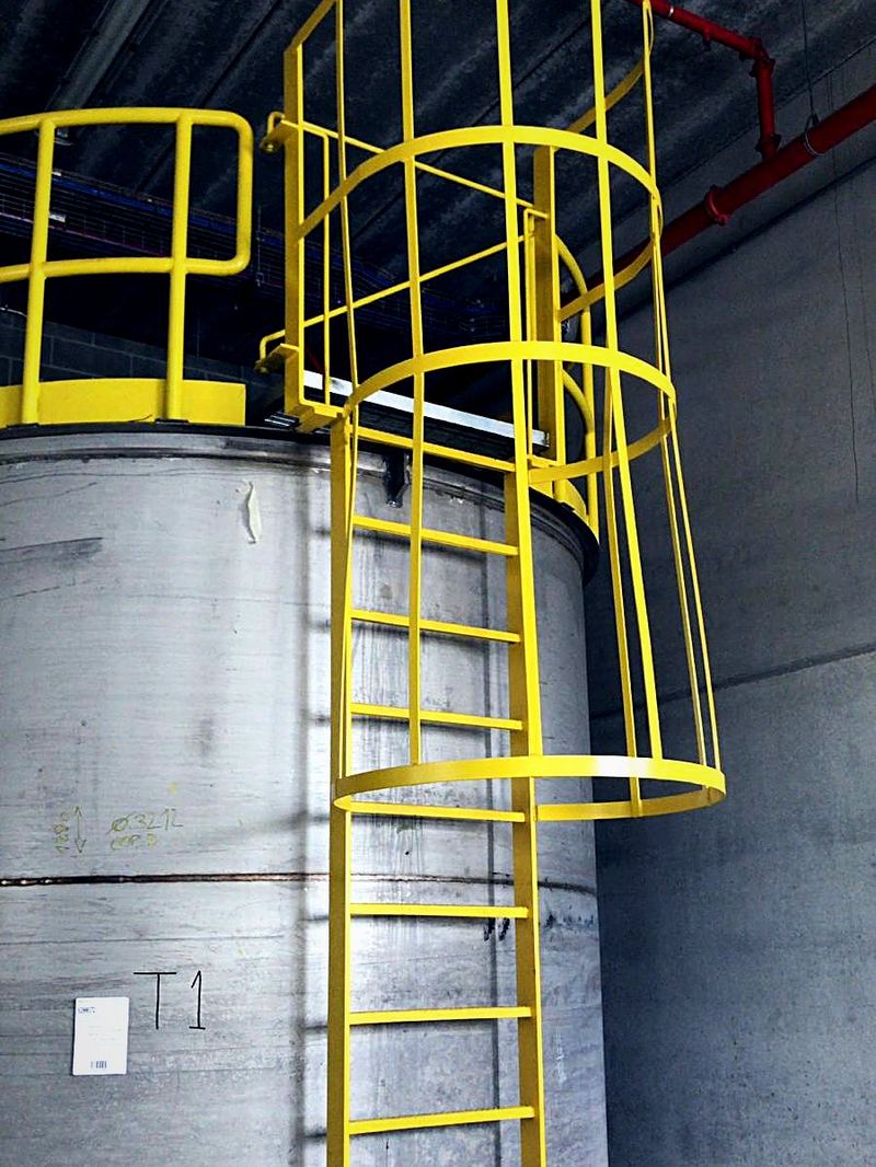 Escalera de gato y barandilla en planta industrial